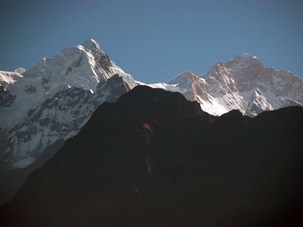 Annapurna 11 01 Manaslu Southwest Face From Dhanagyu I left at 6:20 and after crossing to the Annapurna circuit, I back tracked to upper Dharapani (1920m) to get my Annapurna trekking permit stamped. Thirty minutes later, I walked through Bagarchap (2160m), which was also hit by the same storm that produced avalanches in eastern Nepal in November 1995. A landslide roared through Bagarchap and destroyed much of the village, including two lodges. The trek has now entered the east-west Manang valley and travels west up the valley with high Himalayan peaks to the south. From Dhanagyu I looked toward Manaslu and the Southwest face popped up above the intervening ridge.